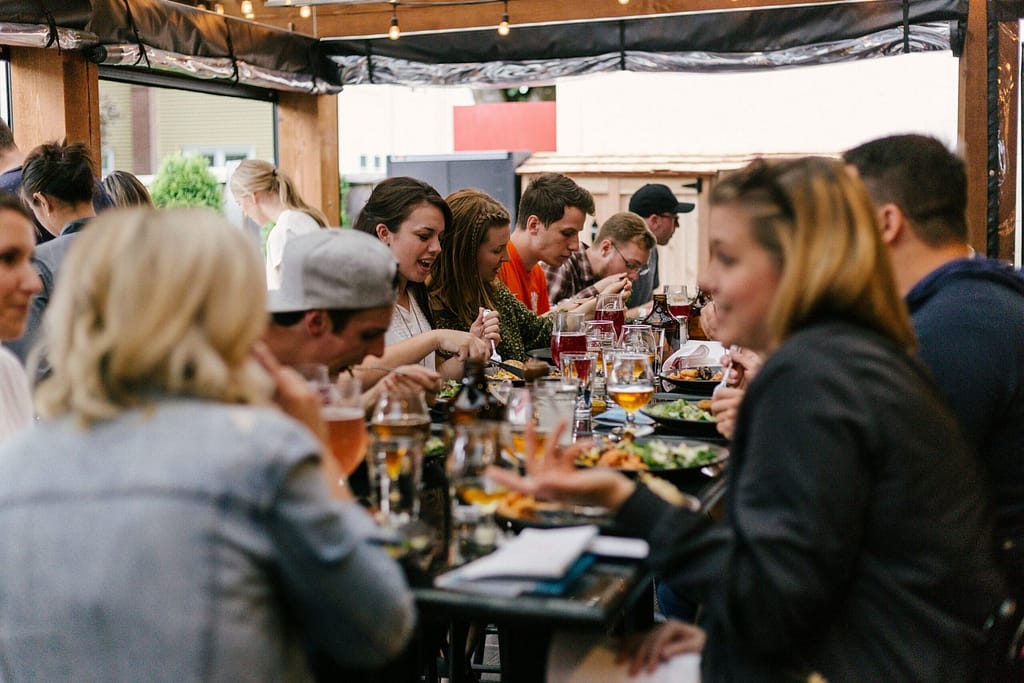 A lively group of individuals seated at a table, sharing food and enjoying each other's company