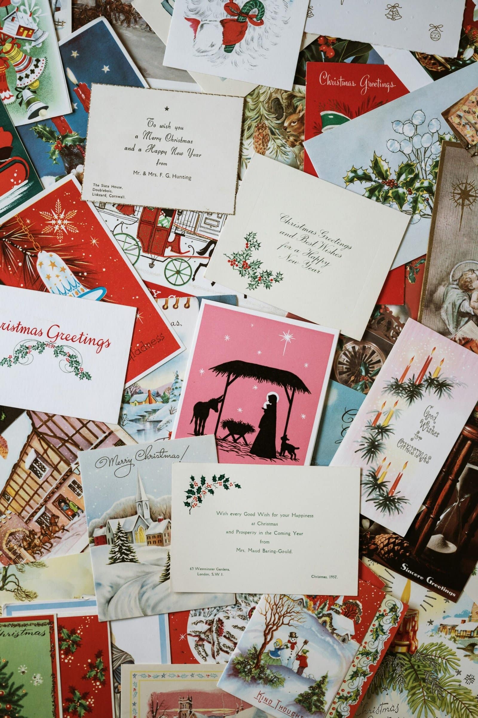 A colorful pile of Christmas cards featuring various festive designs and patterns, ready to be sent out for the holidays.