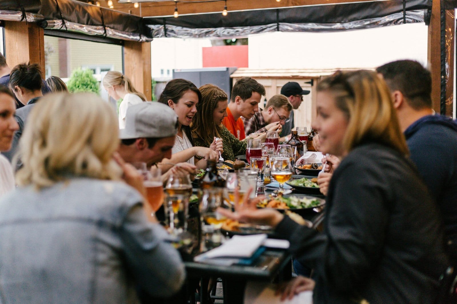 A lively group of individuals seated at a table, sharing food and enjoying each other's company